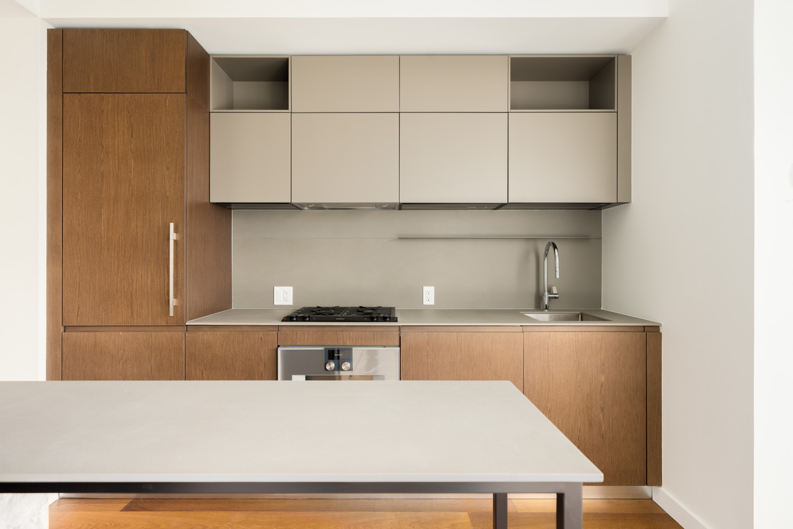Modern kitchen with wood-toned lower cabinets, gray upper cabinets, gas cooktop, and island at 1277 Hornby St, Vancouver.