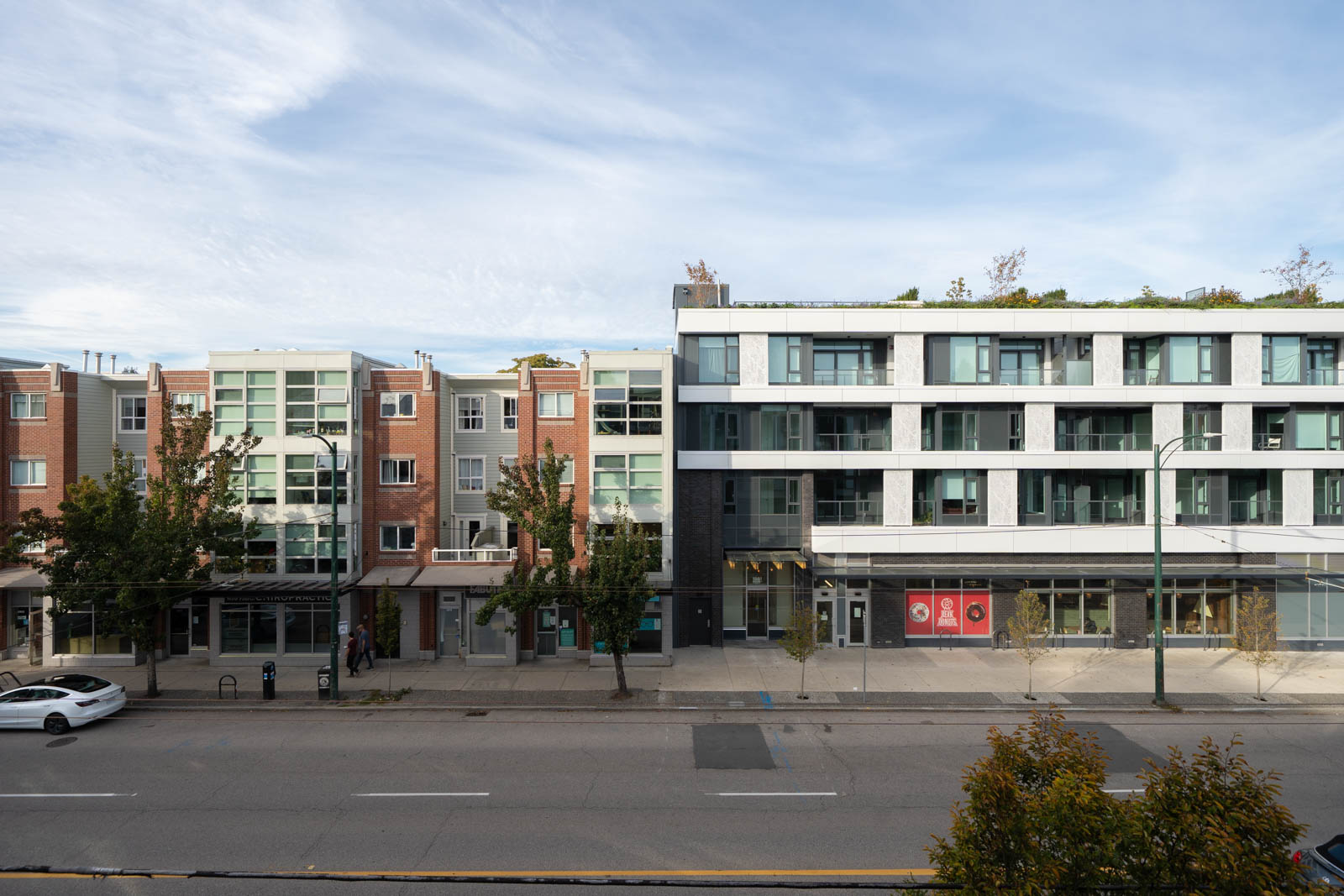 Street view of a brick apartment building next to a modern white and grey complex at 2858 W 4th Ave, Vancouver.