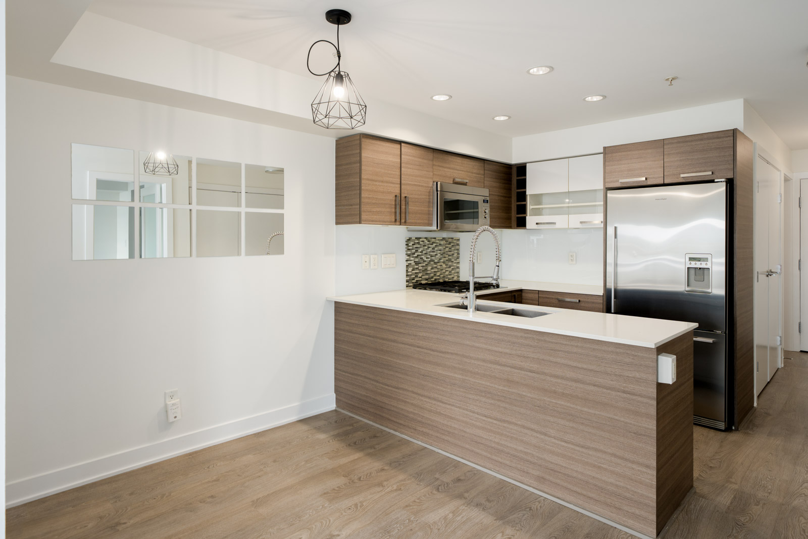 Kitchen with wood-tone cabinets, white counters, stainless appliances, and tile backsplash at 2858 W 4th Ave, Vancouver.