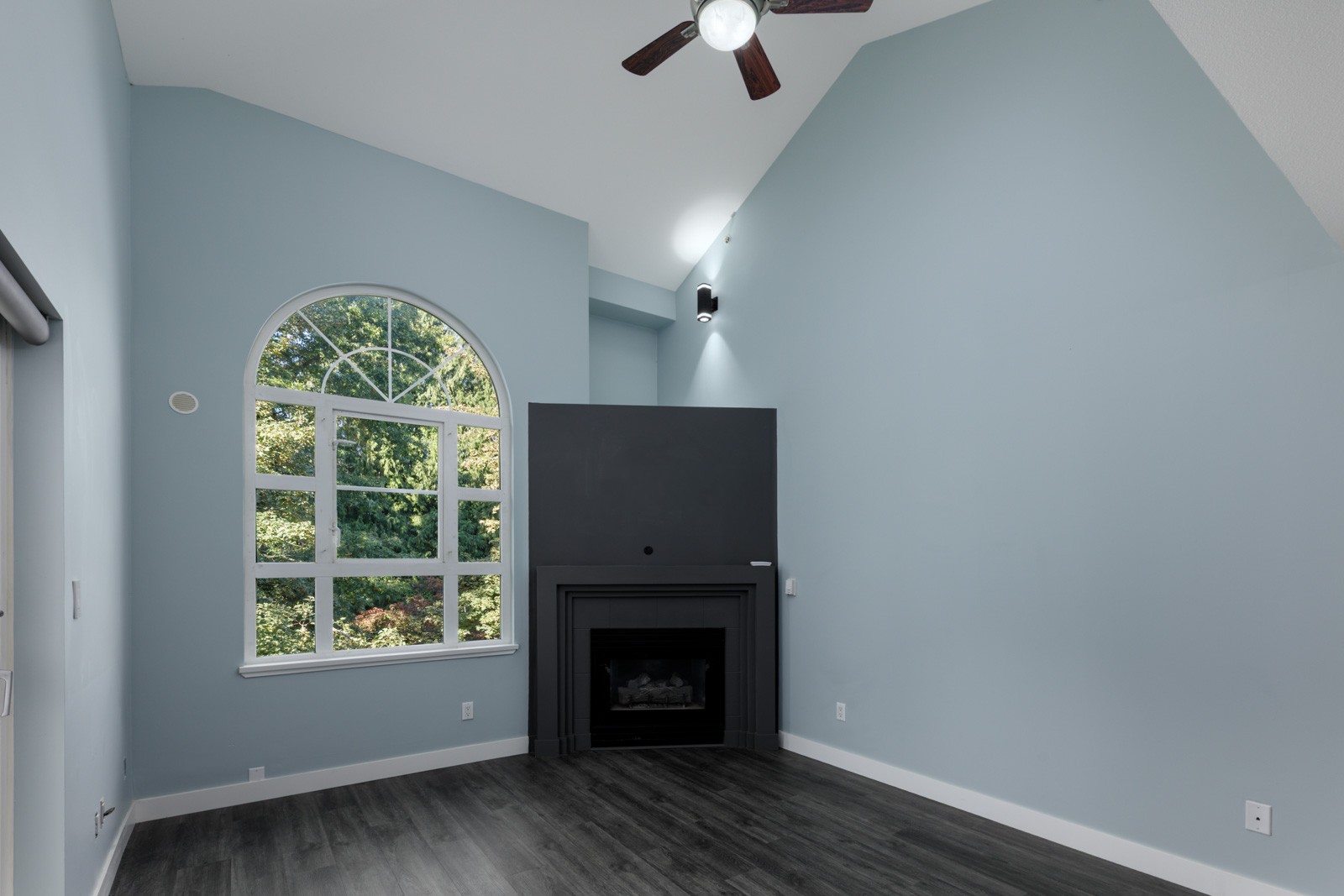 Light blue living room on 3rd floor at 2231 Welcher Ave, Port Coquitlam, with vaulted ceiling, arched window, and wood floors.