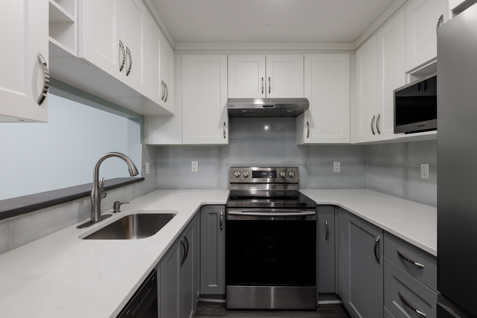 Modern kitchen on the 3rd floor at 2231 Welcher Ave, Port Coquitlam with white uppers, gray lowers, and stainless appliances.