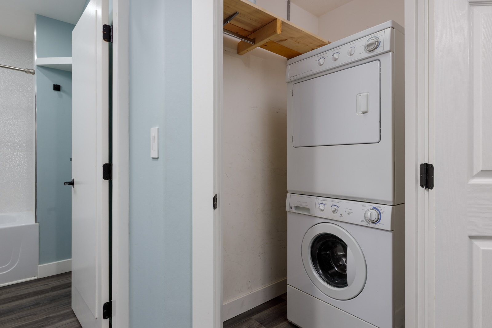 Stacked washer and dryer in a small 3rd-floor closet next to a bathroom with bathtub at 2231 Welcher Ave, Port Coquitlam.