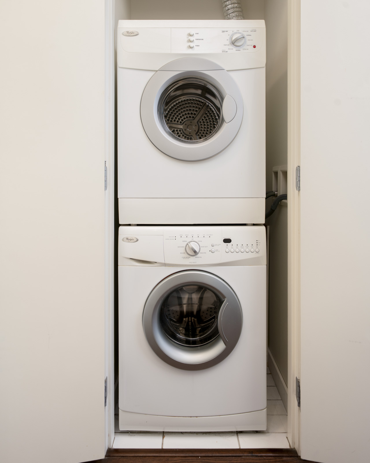 White stackable Whirlpool washer and dryer in a 3rd floor apartment closet at 4818 Eldorado Mews.