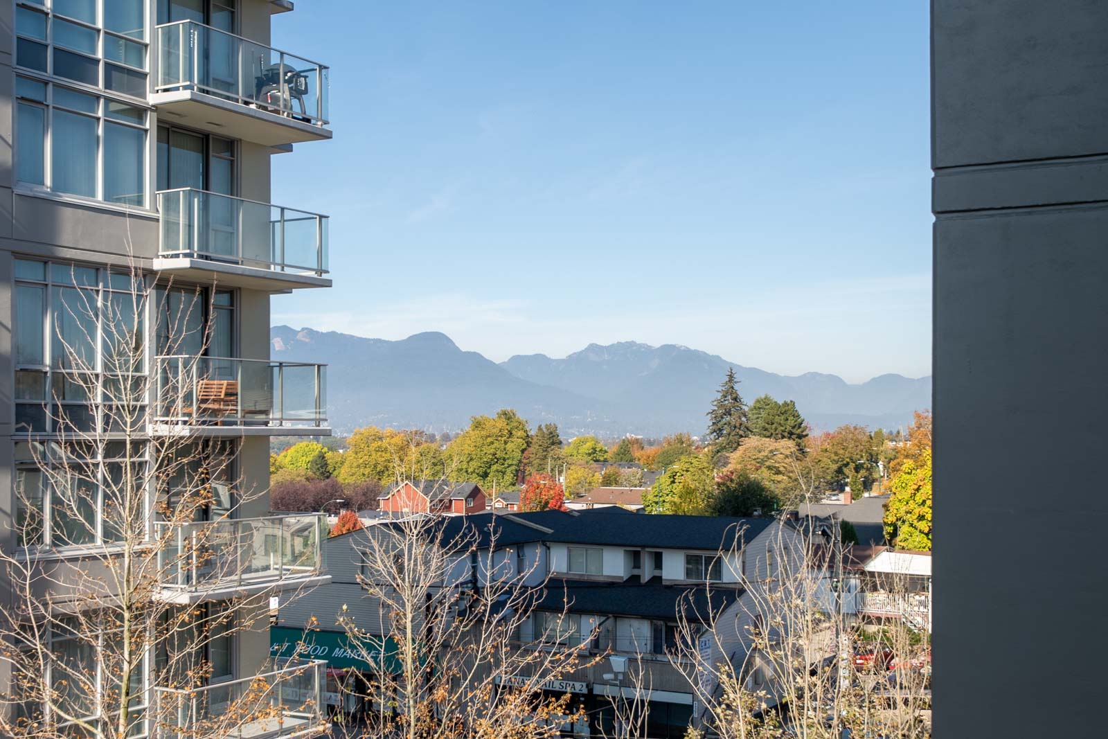 Suburban rooftops, autumn trees, and distant mountains seen from a 3rd-floor apartment at 4818 Eldorado Mews.