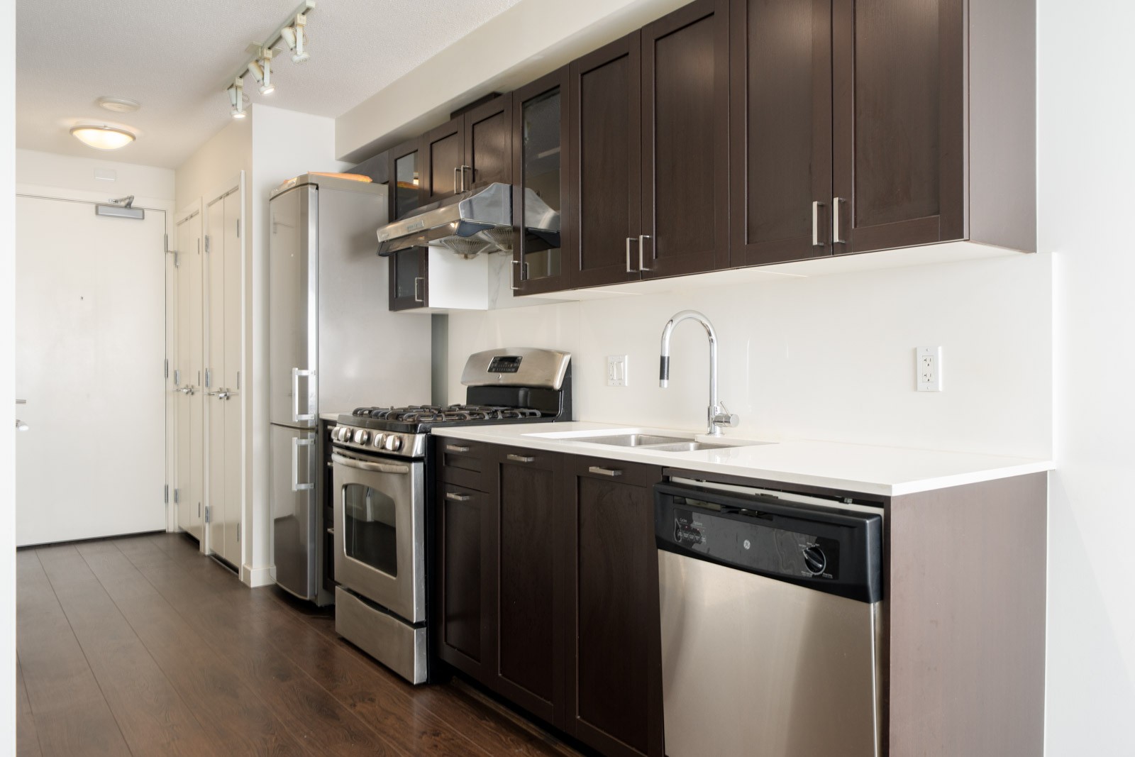 Kitchen with dark wood cabinets, stainless steel appliances, and white countertops at 4818 Eldorado Mews.