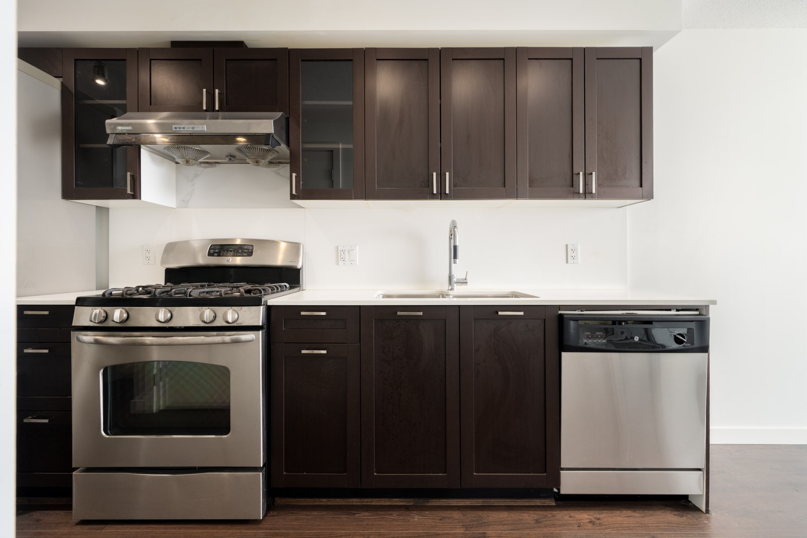 Kitchen at 4818 Eldorado Mews with dark wood cabinets, white countertops, stainless steel gas range, and dishwasher.