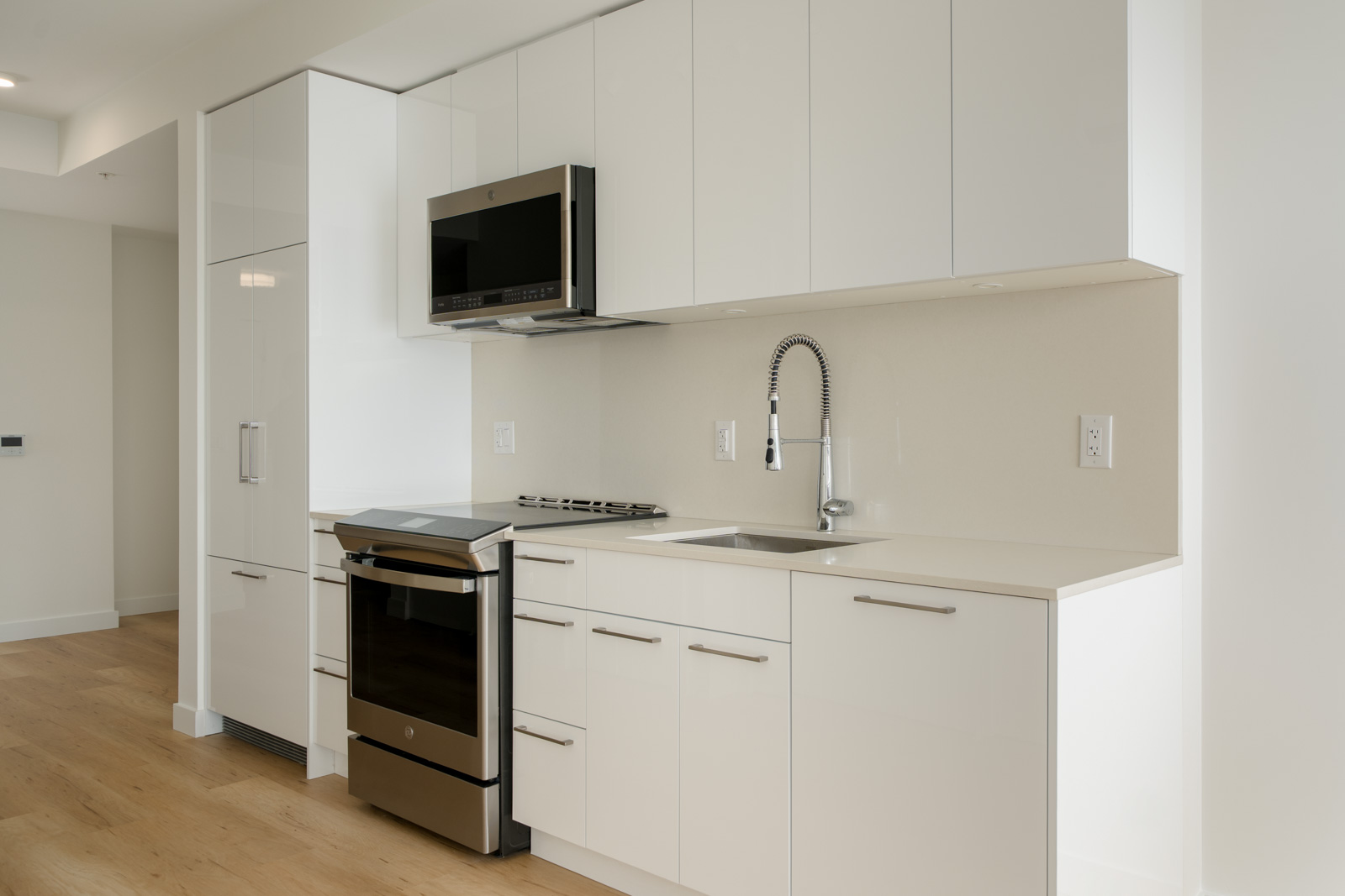 Modern kitchen at 2446 Shaughnessy St 2nd floor office with white flat-panel cabinets, stainless appliances, and light counter.