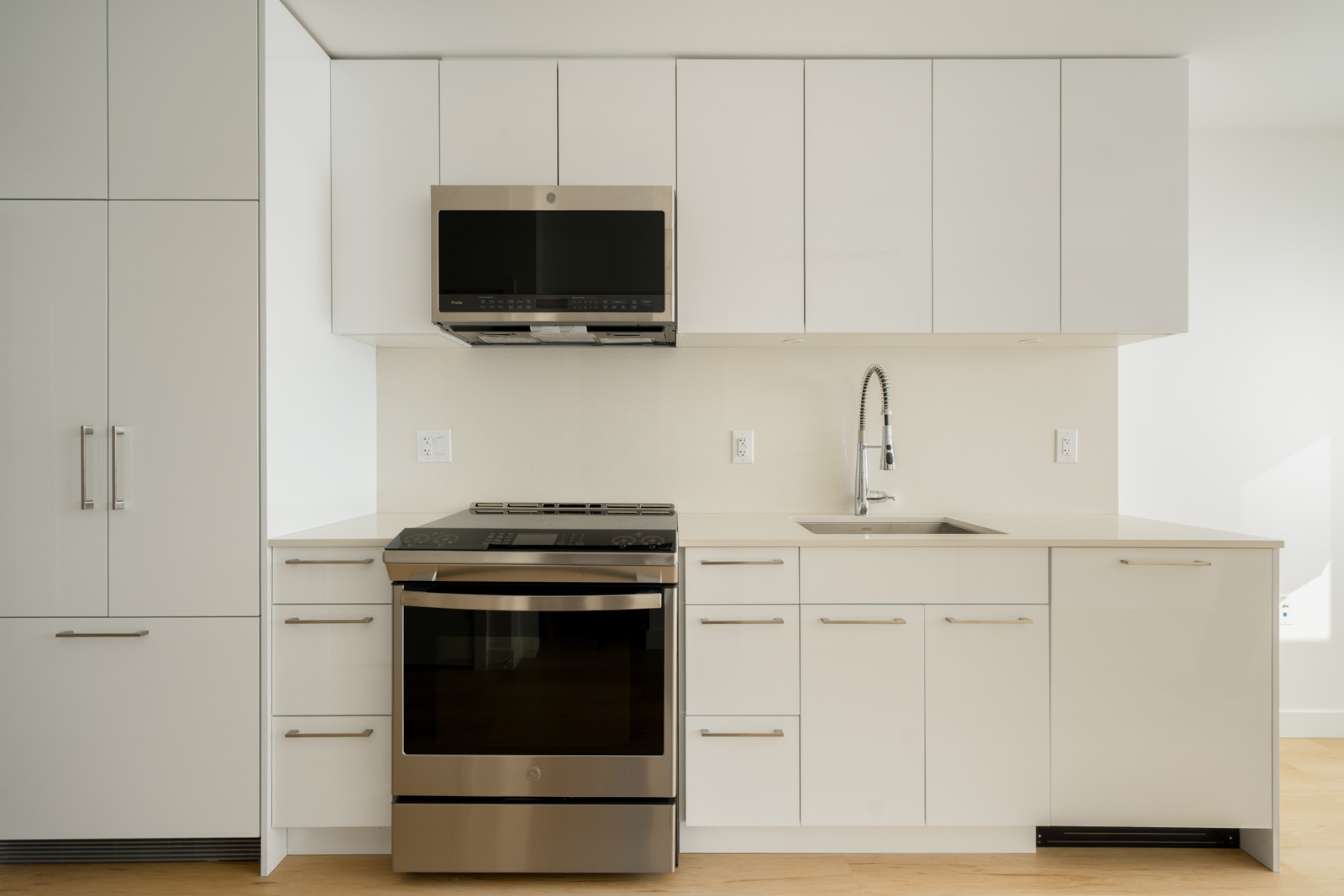 Modern kitchen with white cabinets, stainless steel stove, and microwave at 2446 Shaughnessy St, Port Coquitlam.