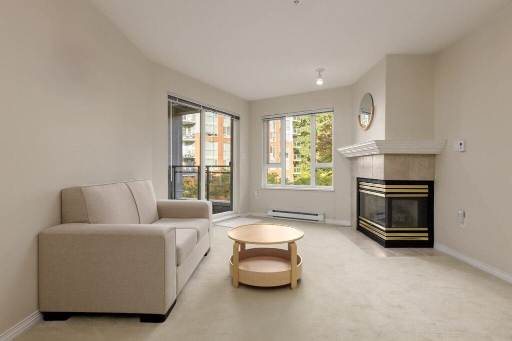 Living room at 5683 Hampton Pl featuring a beige sofa, round wooden coffee table, fireplace, and city view windows.