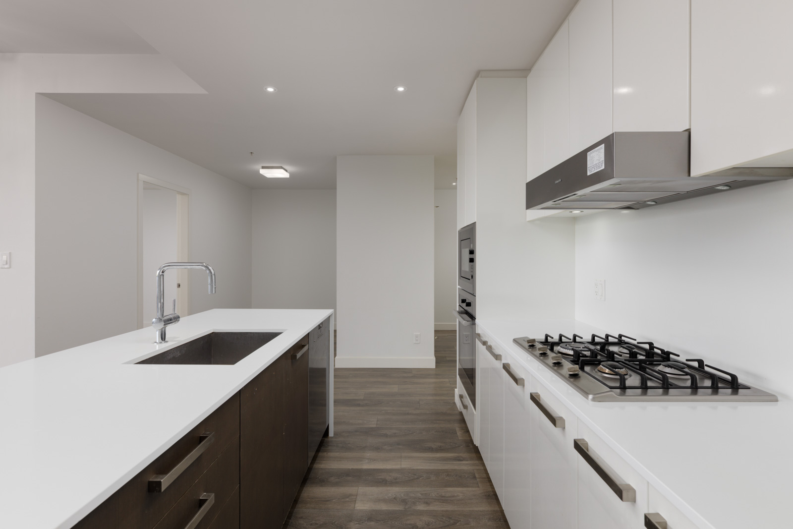 Modern kitchen at 5699 Baillie St featuring a white island, dark lower cabinets, white upper cabinets, and a gas cooktop.