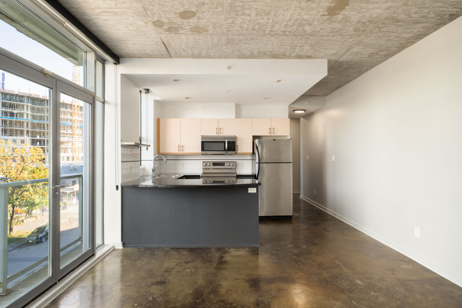 Modern kitchen at the 919 Station Street Vancouver office with light cabinets, stainless steel appliances, and a dark island.