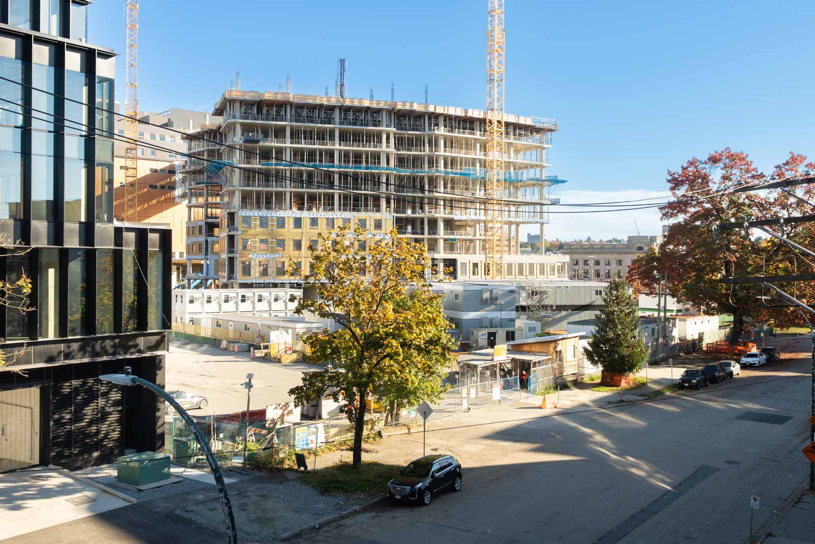 Multi-story building under construction at 919 Station Street, featuring two tower cranes, site offices, and a parking lot.