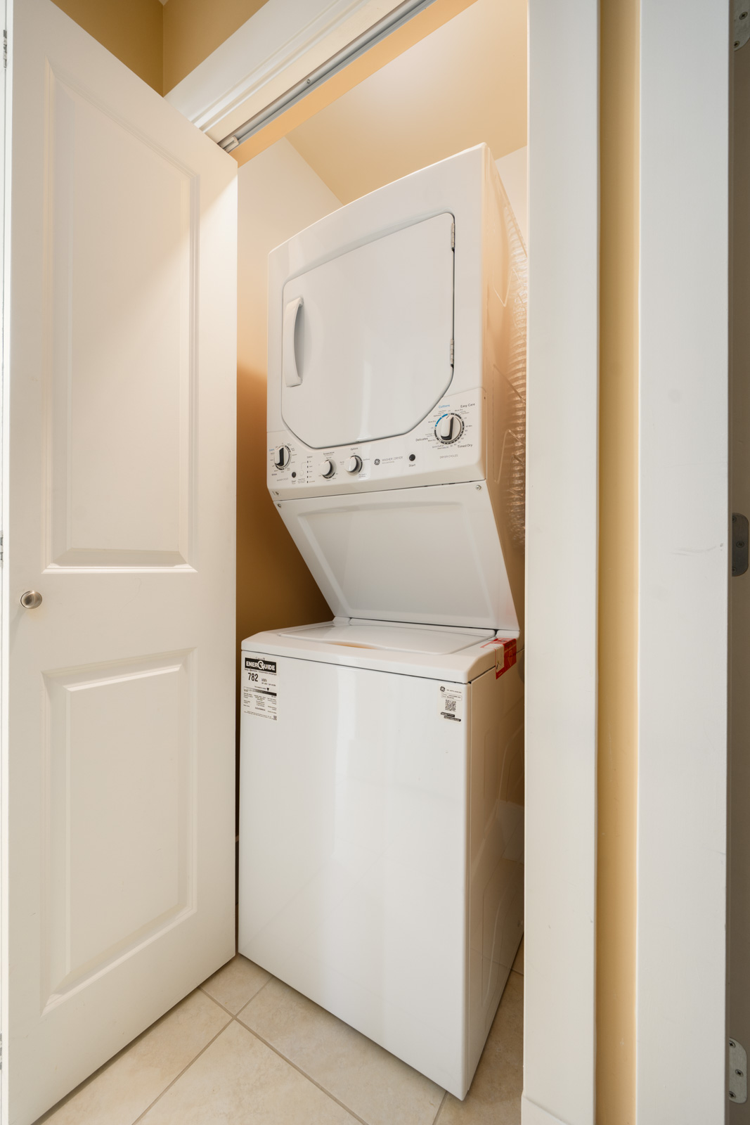 White stacked washer and dryer in a West 22nd Ave basement closet.